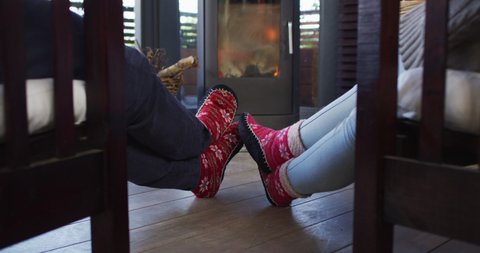 Rear view of a couple holding hands while sitting near the fireplace at vacation home. couple honeymoon and vacation concept