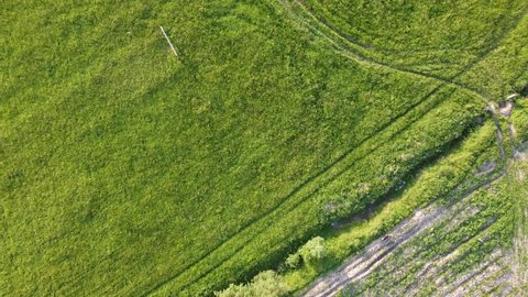 green grass fields captured with quadcopter drone flying over fields in village