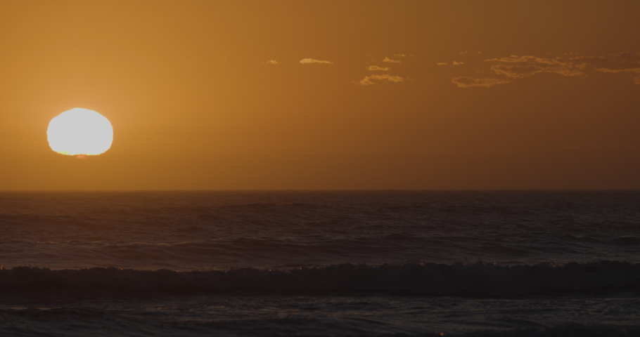 Spectacular sunset view of a large group of Cape Cormorants flying over the Atlantic ocean in slow motion