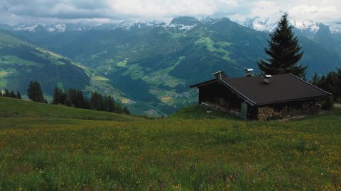 Aerial drone along a cottage lodge and trees in nature at scenic Zillertal skiing sport hiking and trekking vacation mountain valley in the Austrian Bavarian alps on a sunny lush summer day.