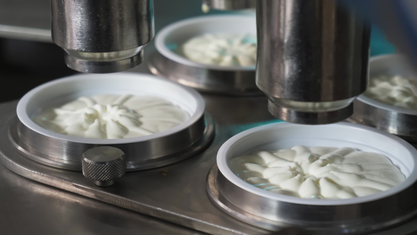 Dairy Food Production Factory. A Stream of Yogurt is Flowing from Automatic Equipment. Yogurt is being filled into the cups. Yogurt Production Line. Manufacturing Process. Industrial Facility. | Shutterstock HD Video #1074385505