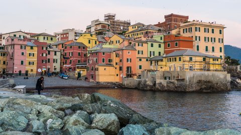 Genoa, Italy - June 09 2021: Time lapse of the old fishing village called Boccadasse at sunset. Boccadasse is an old fishing village located in the center of Genoa, which has remained intact over time