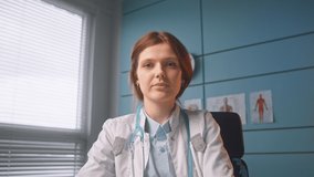 Brunette medical worker in white coat talks on video call