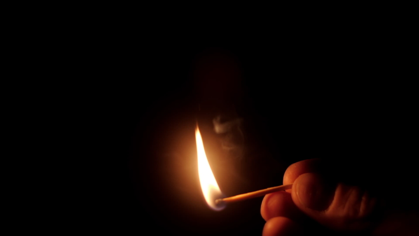 Close up view of fingers hand holding burning match. Ignition of match on black background. Fire concept | Shutterstock HD Video #1074393077