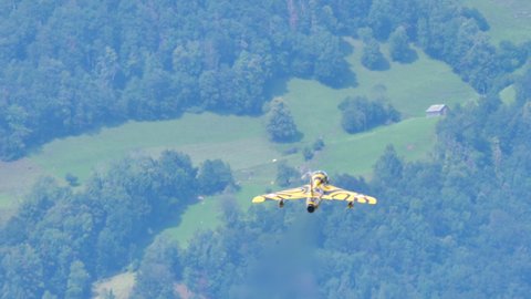 Mollis Switzerland AUGUST, 16, 2019 Aircraft fast climbs into the sky with a green alpine forest in the background. Hawker Hunter trainer military airplane of Swiss Air Force in Tiger color scheme