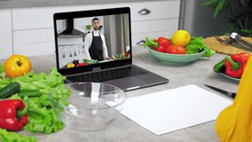 Woman in kitchen study online video call webcam laptop listen chef slices cucumber on cutting board. Man teacher food blogger in computer screen greets tells teaches housewife remote cooking lesson