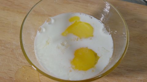 Mixes eggs with milk to make Tornado Omelette