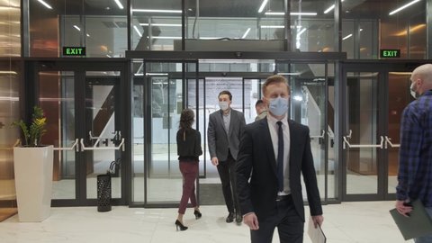 Business people entering and exiting the company, people are wearing a medical mask to protect from coronavirus and to stay healthy.