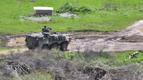 Postojna Slovenia MAY, 20, 2021 Light wheeled armoured vehicles with soldiers on a muddy road of a firing range during a military exercise