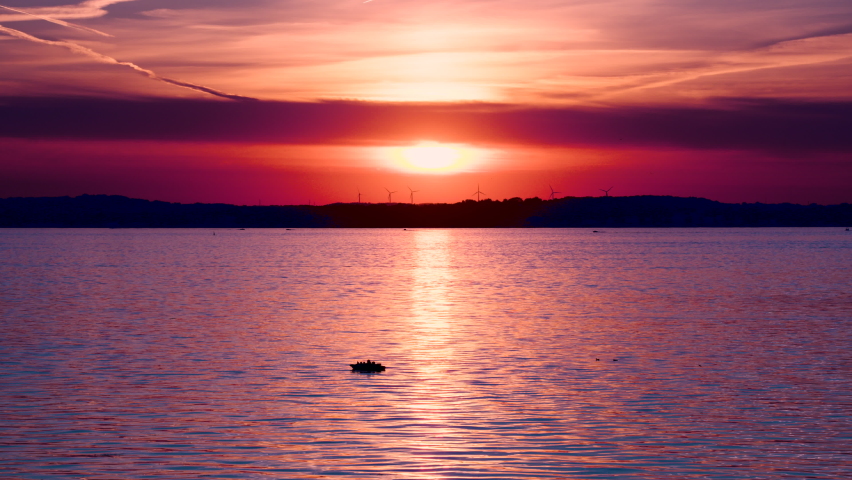 Sun passing through clouds during sunset on a lake