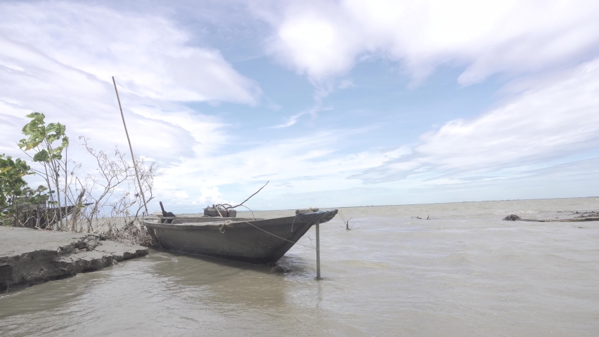 A boat is floating in the river while the river is experiencing erosion.