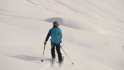 Samoens Refuge de Bostan , Haute Savoie , France - 02 15 2021: Action tracking shot of man skiing downhill a snowy slope in slow motion