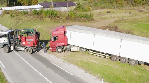 Sentrupert , Slovenia - 10 20 2020: Driver Attaching Towing Vehicle's Rope to Semi Truck on the Roadside