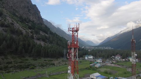 Telecommunication towers in the mountain region needs in the powerful transmitters and antennas. Aerial view to the communication equipment for shared global network, internet and cellular mobile.
