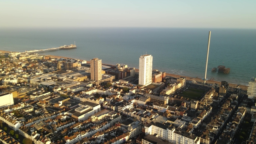 Aerial view of Brighton and Hove at sunset UK, Brighton Waterfront, Royal Pavilion, United Kingdom. I360 and Brighton Pier Royalty-Free Stock Footage #1074431876