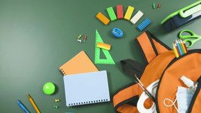 Stop motion. Stationery is stacked in a school backpack. School supplies lie on the green chalkboard. Education concept. - Powered by Shutterstock - Get 15% off with code: PIKWIZARD15