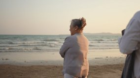 Happy Asian family senior couple, husband covering wife with a blanket and hugging each other on the beach at sunset. Healthy elderly retired people enjoy outdoor lifestyle travel the sea in summer. - Powered by Shutterstock - Get 15% off with code: PIKWIZARD15