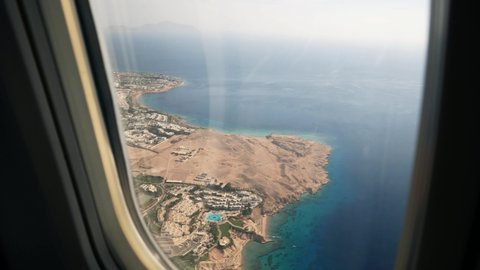 Plane flies over the azure coast with hotels of the Red sea resort excellent Sharm El Sheikh of Egypt 