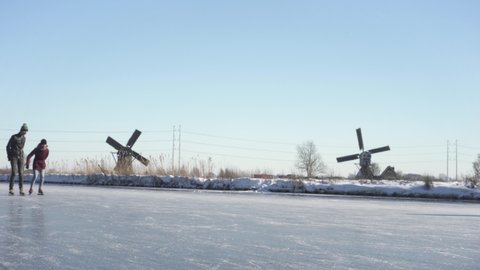 Leiden , Zuid Holland , Netherlands - 02 05 2021: Dutch locals ice skating on frozen canal, fun winter leisure