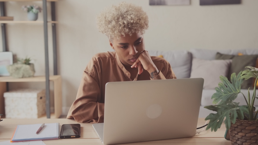 Thoughtful concerned dark skinned female working on modern laptop computer looking away thinking solving problem at home office serious woman search for inspiration make decision feel lack of ideas Royalty-Free Stock Footage #1074453911