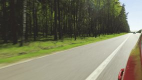Video shooting in motion, the car is driving on a large highway road on a sunny day in summer