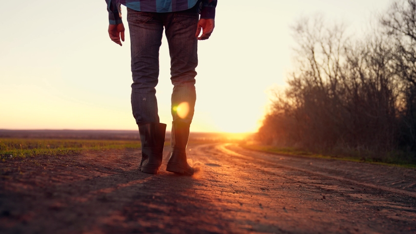 Agriculture. Farmer in rubber boot walks along rural road. Agricultural business. Farmer in rubber boot on a rural road. Business in agriculture. Farmer walks along wheat field. Organic products Royalty-Free Stock Footage #1074470261