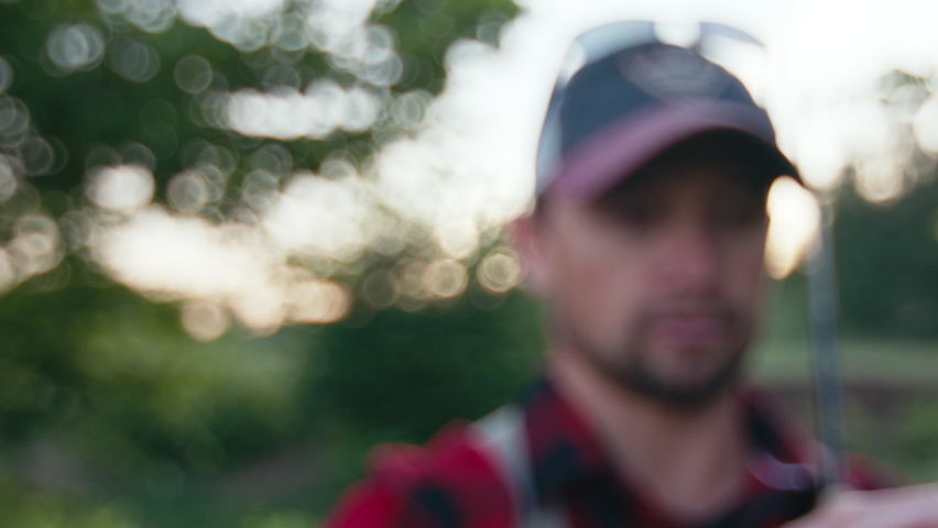 Fly fishing, close up fly details,. Angler stands outdoor and shows his tiny dry fly made with CDC feathers