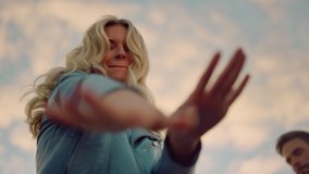 Bottom view cute girl having fun with friends at sunset disco. Closeup smiling woman dancing for camera at outdoors. Cheerful female person moving hands to beat of music at party. - Powered by Shutterstock - Get 15% off with code: PIKWIZARD15