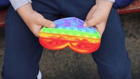 video mp4 child playing colorful anti-stress popit on the street top view