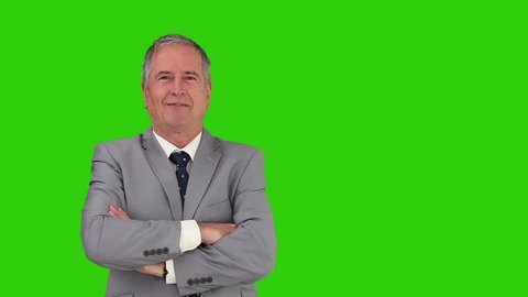 Elderly businessman looking at the camera against a green screen