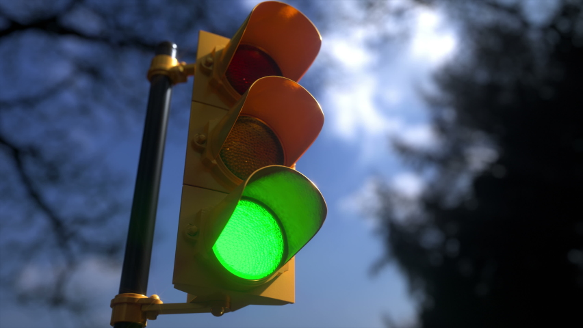 Outdoor vertical traffic light with blue sky and trees around. Traffic control concept image with shallow depth of field. | Shutterstock HD Video #1074479366