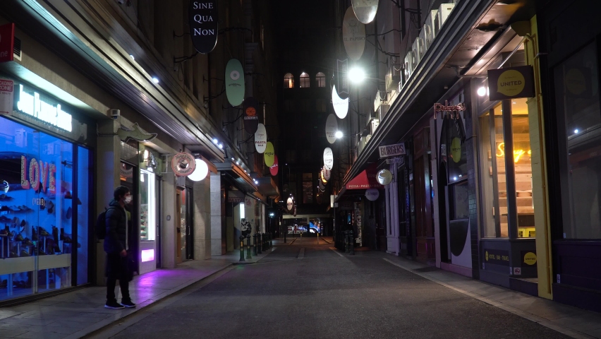 Man wearing a mask walks through the empty Melbourne city during the nightly curfew as Victorian, Australia battles the coronavirus outbreak in 2020-21.