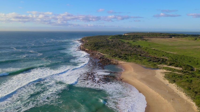 Crashing Waves On Sand And Rocks At Maroubra Beach. Malabar Headland National Park In New South Wales, Australia. aerial drone descend
