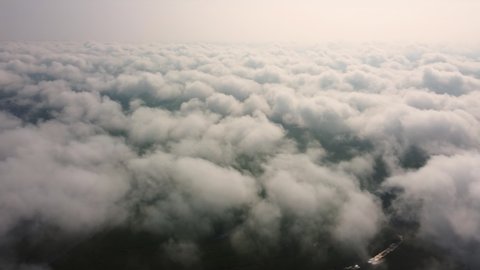View from the airplane window to the clouds from above.