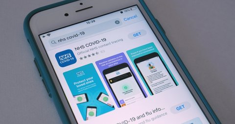 Kumamoto, JAPAN - Jun 14 2021 : Man searches NHS COVID-19 app in App Store and watches intro. It is a contact tracing app for monitoring the spread of the COVID-19 pandemic in England and Wales