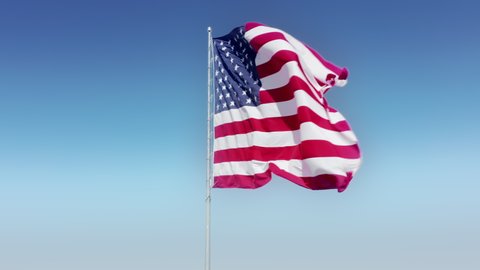 American background. Cinematic aerial slow motion 4K footage of US flag waving on clear blue sky background. Scenic large symbol and landmark of United States of America. Copy and text space video