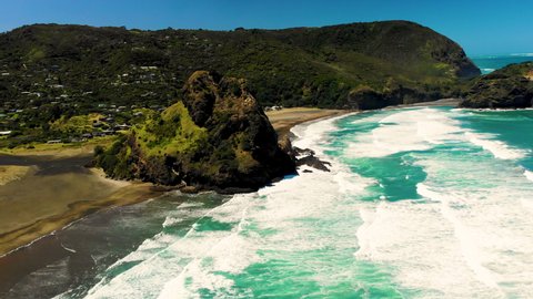 Ocean waves crashing volcanic rock formation on New Zealand coastline, Piha