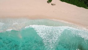 Drone video on the coastline, drone camera pointing down to the beach and ocean waves, Seychelles