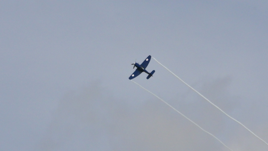 Duxford Aerodrome UK JULY, 11, 2015 Blue propeller fighter military plane in flight with white trails on the wing tips. Hawker Sea Fury of Royal Australian Navy.