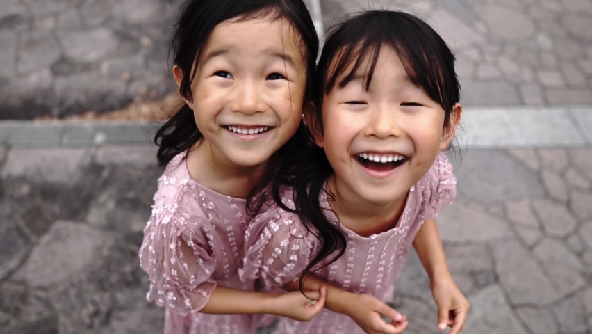 Video of smiling Asian twin girls