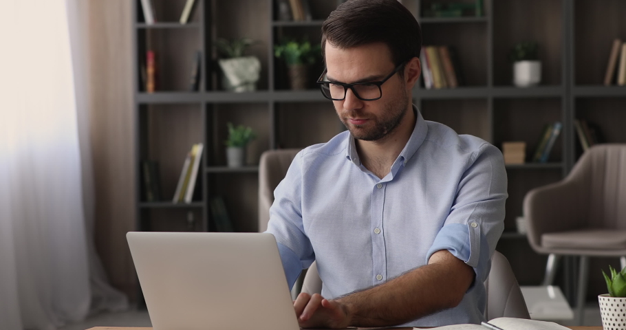 Millennial handsome man finished project on computer takes off glasses lean on comfortable ergonomic office chair relaxing put hands behind head. Stress relief after succeed result work done concept Royalty-Free Stock Footage #1074542315