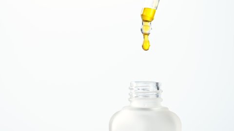 Super Slow Motion Shot of Oily Essence Drop into Phial isolated on White Background at 1000fps.