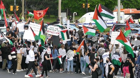 Mississauga , Canada - 05 18 2021: Demonstrators holding sign saying Fear The Prayer Of The Oppressed and the rest waving Palestinian flags for pro-Palestinian rally in Mississauga organized by Palest