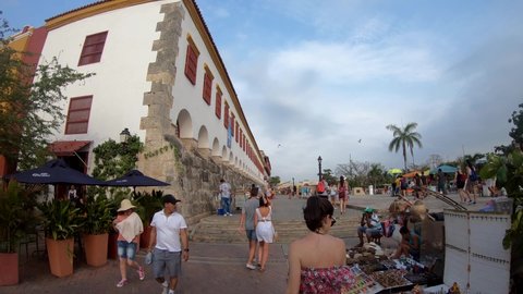 Cartagena de Indias , Bolívar , Colombia - 02 17 2019: Tourists are walking in a large plaza with colorful houses