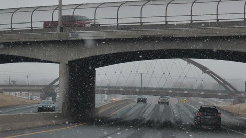 Denver , Colorado , United States - 01 24 2021: Winter Traffic, Falling Snow, Overpass Bridge, Cars on Wet Highway, Slow Motion