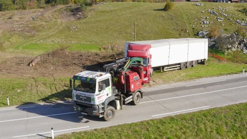 Sentrupert, Slovenia - 10 20 2020: Aerial view of towing truck tows a broken down long lorry truck in a mountain