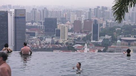 Singapore, Southeast Asia, Singapore - 02 28 2019: Tourist Guests relax on Infinity Pool at the famous Marina Bay Sands Hotel
