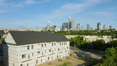 Charlotte , North Carolina , United States - 05 01 2021: Drone Flies Past New Home being Built with Charlotte Skyline in Background