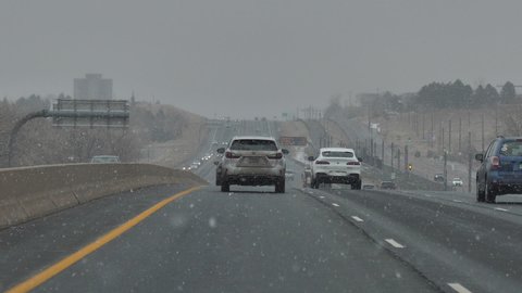 Denver , Colorado , United States - 01 10 2021: Slow Traffic on Interstate Highway on Snowy Winter Day. Slow Motion