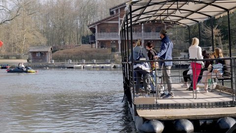 Brussels , Belgium - 03 27 2021: A small group of people taking the ferry across the pond at Bois de la Cambre